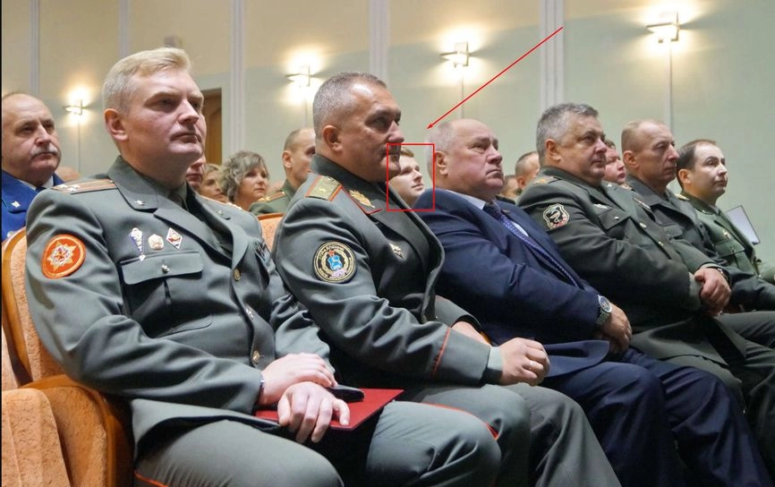 Aleksei Lobeev peeks out from behind the chin of GRU head Ruslan Kosygin