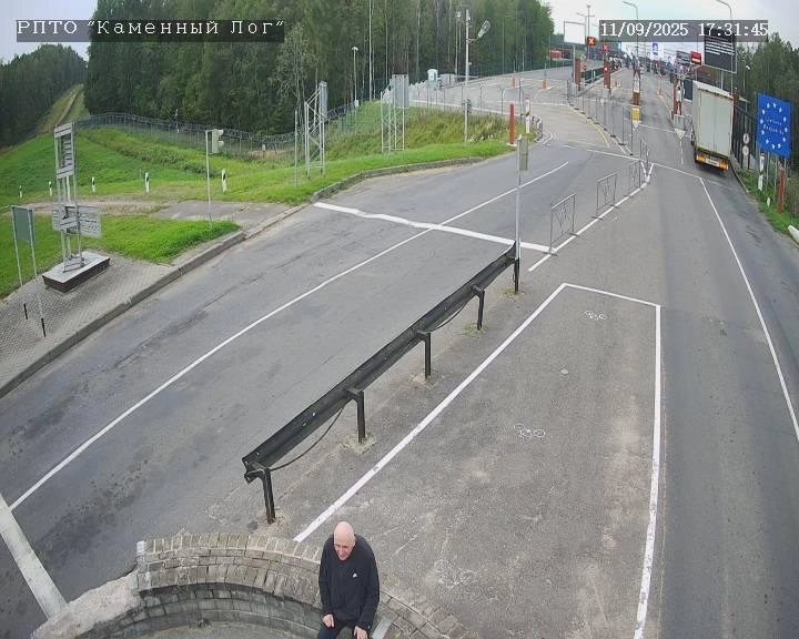 Mikola Statkevich in the "neutral zone" between the state borders of Belarus and Lithuania. The entry point to the latter, marked by a sign with an EU flag, can be seen in the background.